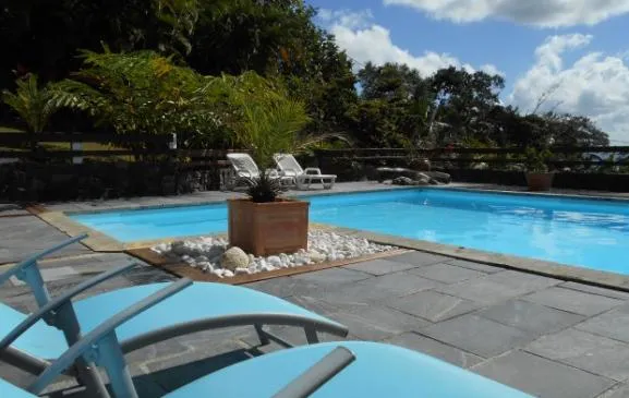 Gîte en bois, coeur d'un jardin luxuriant comportant une ancienne maison créole et piscine