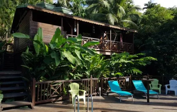 Bungalow bois dans jardin tropical vue mer et piscine